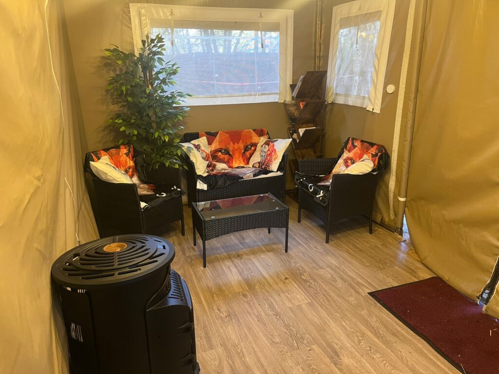 Le salon du lodge avec ses fauteuils et son poil a bois